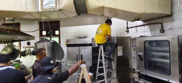 Technicians servicing kitchen equipment